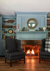 A fireplace with two chairs in front of it.